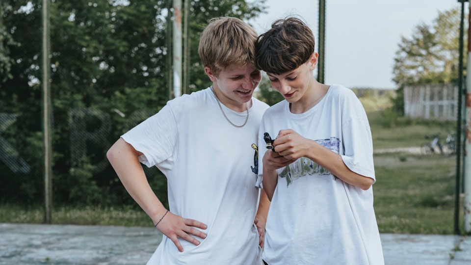 Två killare kollar på en telefon